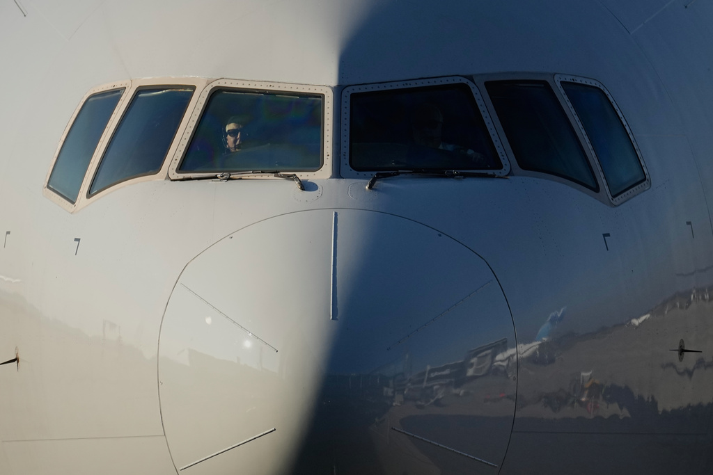 A pilot looks out of a cockpit window as the airplane of the Colts football team arrives from Indianapolis at the airport ahead of the upcoming NFL game between the Indianapolis Colts and the Atlanta Falcons in Berlin, Germany, Friday, Nov. 6, 2025. (AP Photo/Martin Meissner)