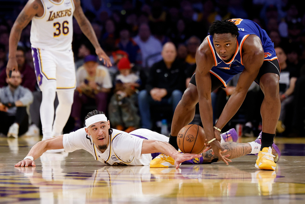 Los Angeles Lakers center Jaxson Hayes, bottom, and New York Knicks forward Og Anunoby, right, fight for possession of the ball during the first half of an NBA basketball game, Sunday, March 8, 2026, in Los Angeles. (AP Photo/Caroline Brehman)