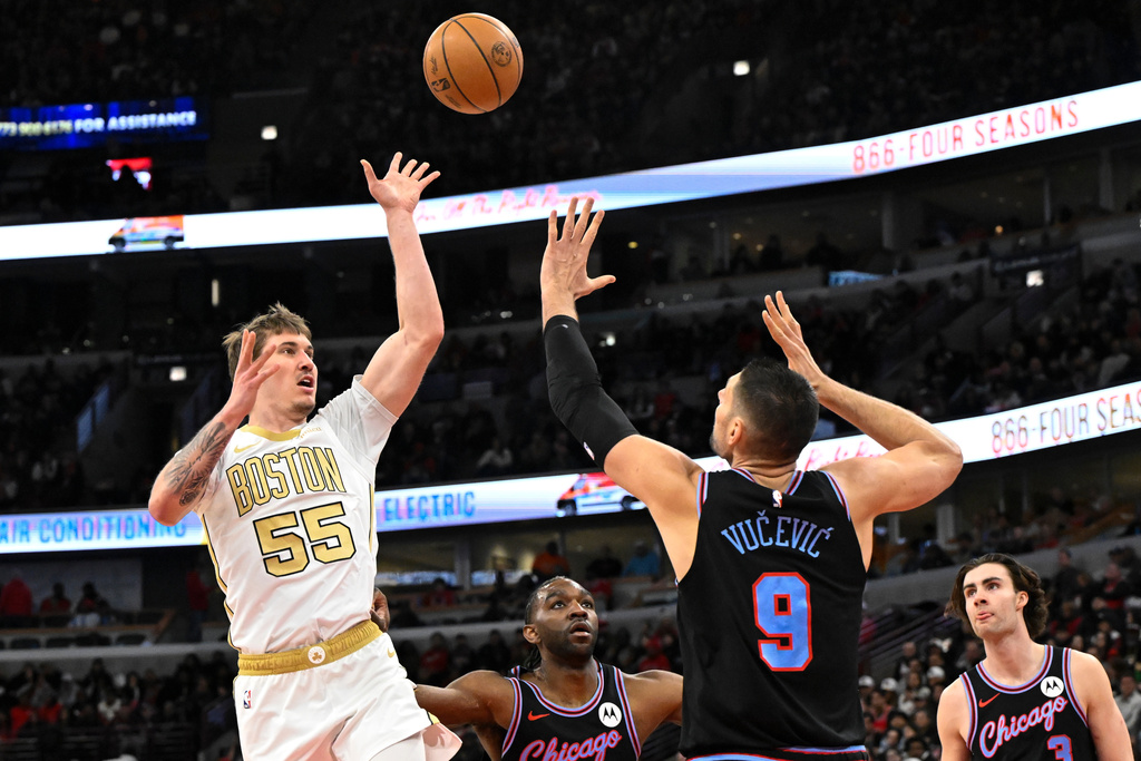 Boston Celtics guard Baylor Scheierman (55) shoots against Chicago Bulls center Nikola Vucevic (9) during the first half of an NBA basketball game Monday, Jan. 24, 2026, in Chicago. (AP Photo/Matt Marton)