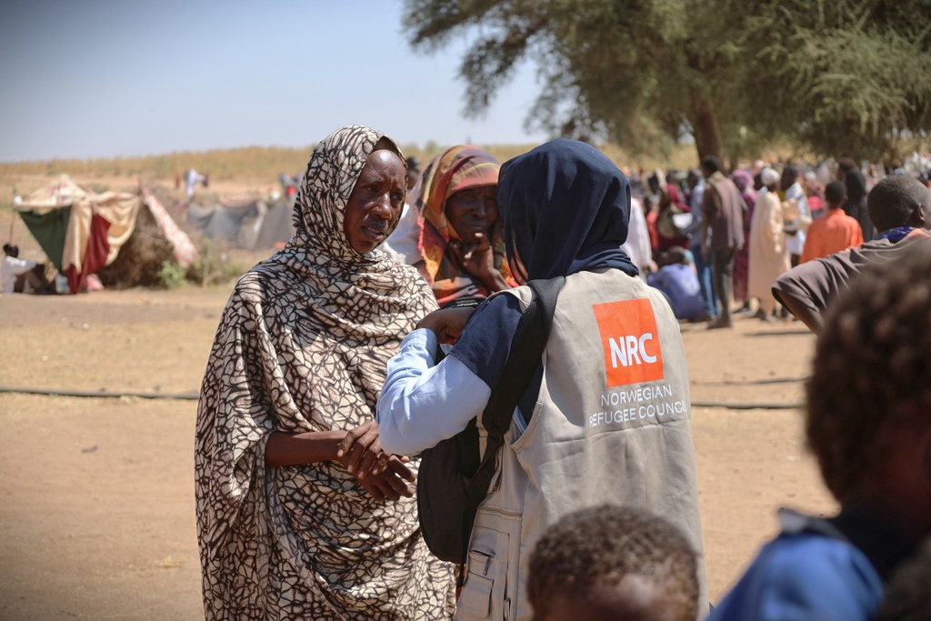 This photo released by The Norwegian Refugee Council (NRC), shows a woman talking with an aid worker at a displacement camp where residents from el-Fasher sought refuge from fighting between government forces and the RSF, in Tawila, Darfur region, Sudan, Monday, Nov. 3, 2025. (Sarah Vuylsteke/NRC via AP)