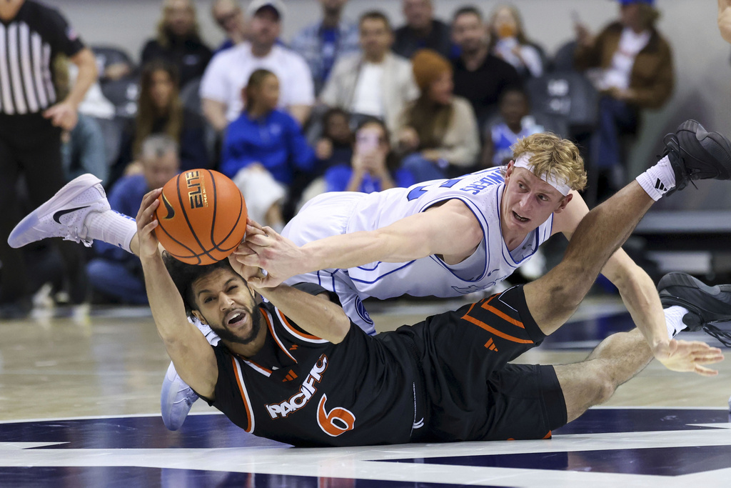 Pacific guard Jaden Clayton (6) and BYU guard Richie Saunders (15) go to the floor for a loose ball during the second half of an NCAA basketball game, Tuesday, Dec. 16, 2025, in Provo, Utah. (AP Photo/Rob Gray)