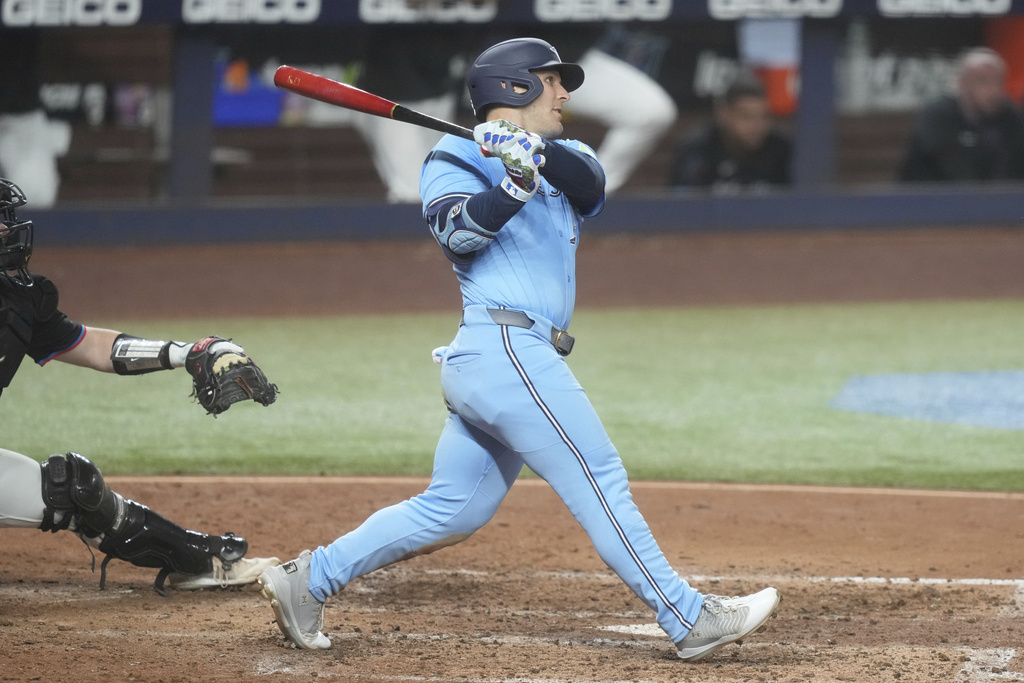 Toronto Blue Jays' Daulton Varsho hits a two-run home run during the sixth inning of a baseball game against the Miami Marlins, Friday, Aug. 22, 2025, in Miami. (AP Photo/Marta Lavandier)