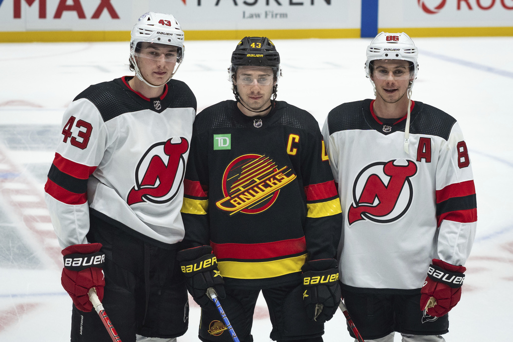 FILE -New Jersey Devils' Luke Hughes, left, Vancouver Canucks' Quinn Hughes and Devils' Jack Hughes, who are brothres, pose for a photo before an NHL hockey game in Tuesday, Dec. 5, 2023, in Vancouver, British Columbia. (Ethan Carins/The Canadian Press via AP, file)