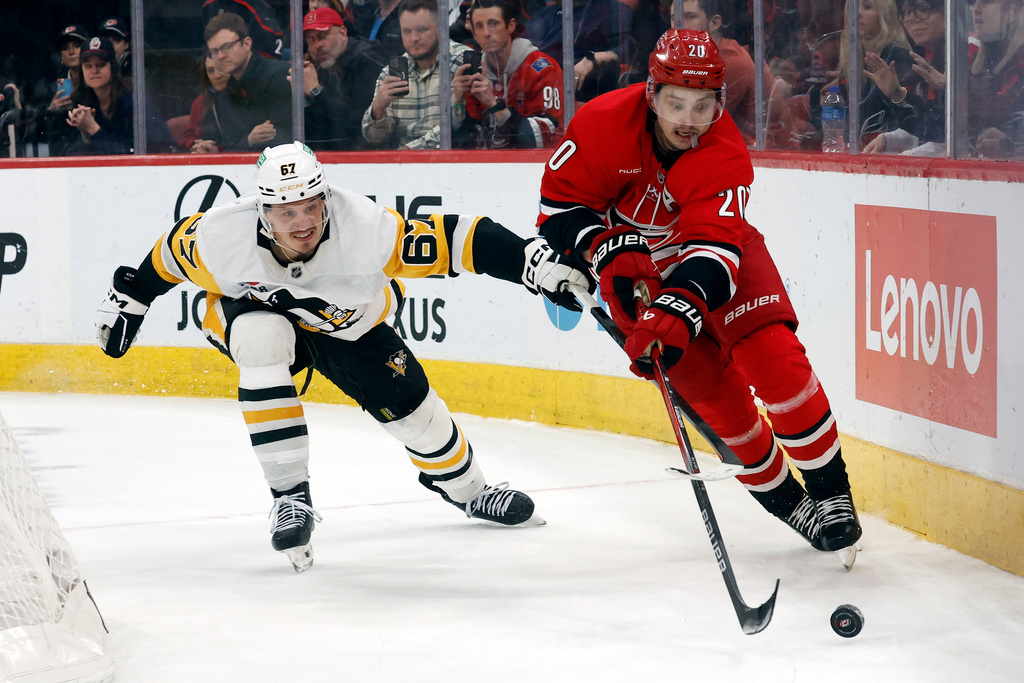 Carolina Hurricanes' Sebastian Aho (20) controls the puck in front of Pittsburgh Penguins' Rickard Rakell (67) during the third period of an NHL hockey game in Raleigh, N.C., Wednesday, March 18, 2026. (AP Photo/Karl DeBlaker)