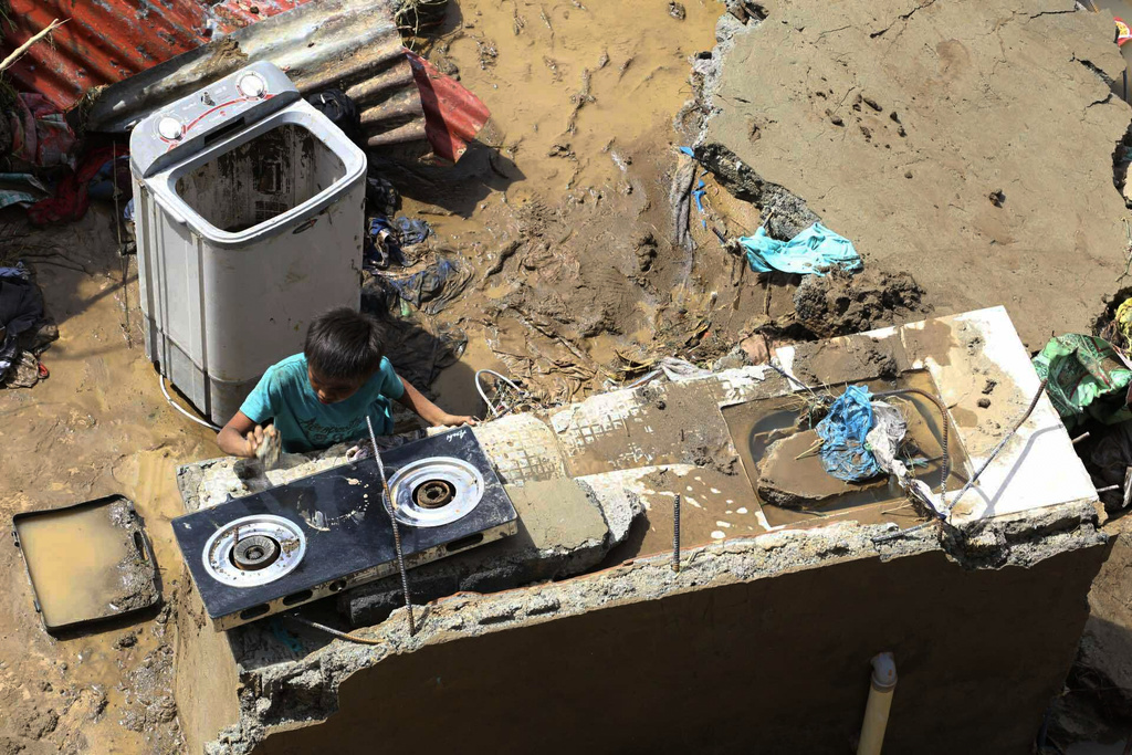 A resident salvages items from their damaged homes after Typhoon Kalmaegi caused devastation in communities along the Mananga River in Talisay City, Cebu province, central Philippines, Wednesday, Nov. 5, 2025. (AP Photo/Jacqueline Hernandez)