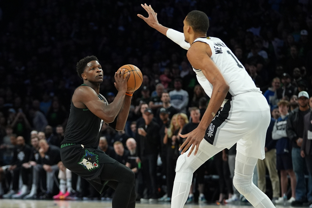 Minnesota Timberwolves guard Anthony Edwards, left, looks to shoot against San Antonio Spurs forward Victor Wembanyama (1) during the first half of Game 4 of an NBA basketball second-round playoffs series in Minneapolis, Sunday, May 10, 2026. (AP Photo/Abbie Parr)