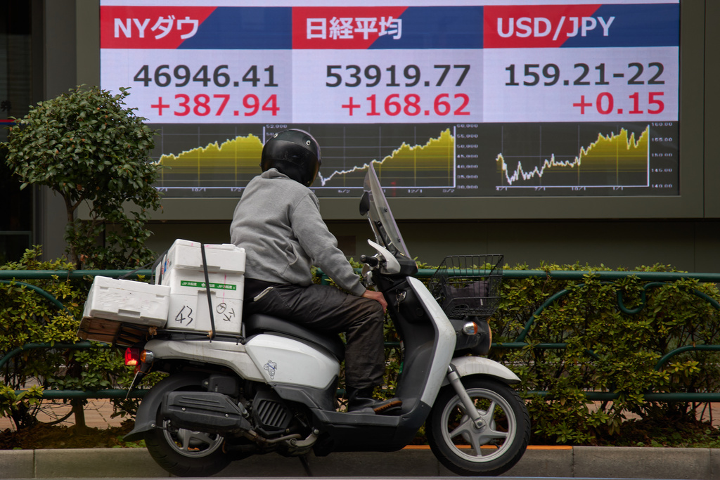 A person looks at a stock price monitor showing New York Dow and Nikkei indexes also US dollar Japanese yen exchange rate at a security company Tuesday, March 17, 2026, in Tokyo. (AP Photo/Eugene Hoshiko)