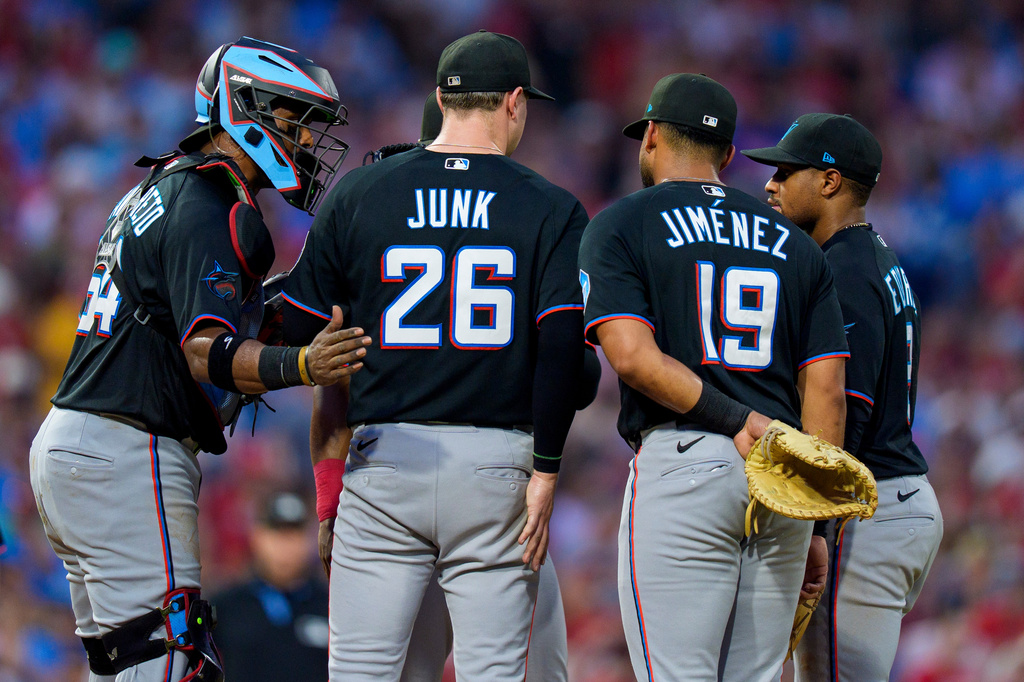 Miami Marlins starting pitcher Janson Junk (26) talks with catcher Brian Navarreto, left, first baseman Leonardo Jimenez (19) and second baseman Xavier Edwards, right, during the third inning of a baseball game against the Philadelphia Phillies, Monday, Aug. 17, 2026, in Philadelphia. (AP Photo/Chris Szagola)