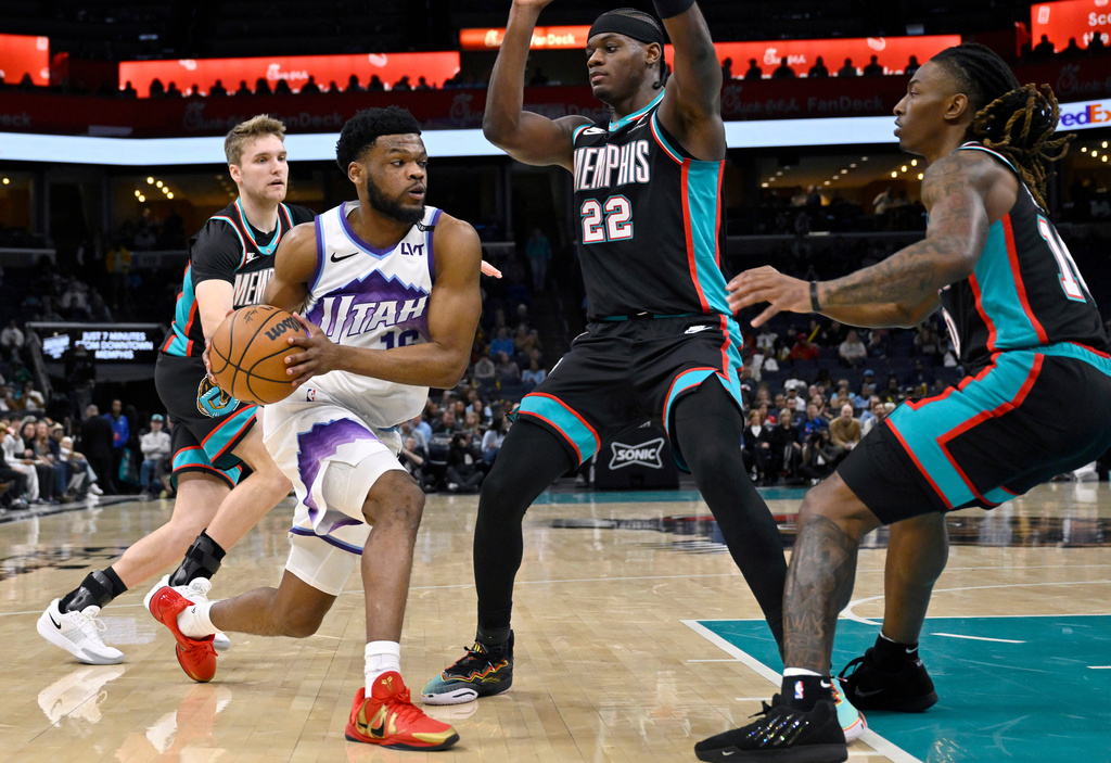 Utah Jazz guard Elijah Harkless, front left, handles the ball against Memphis Grizzlies guard Cam Spencer, back left, forward Taylor Hendricks (22) and guard Javon Small, right, in the first half of an NBA basketball game Friday, Feb. 20, 2026, in Memphis, Tenn. (AP Photo/Brandon Dill)