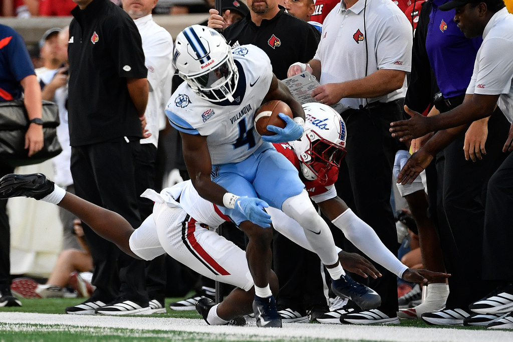 Villanova running back Ja'briel Mace (4) avoids the tackle attempt by Louisville defensive back DJ Waller (12) during the first half of an NCAA college football game in Louisville, Ky., Friday, Sept. 11, 2026. (AP Photo/Timothy D. Easley)