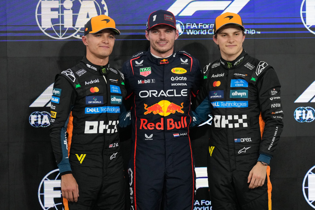 From the left, secon-placed McLaren driver Lando Norris of Britain, first-placed Red Bull driver Max Verstappen of the Netherlands and third-placed McLaren driver Oscar Piastri of Australia stand on the podium after the qualifying for the he Abu Dhabi Formula One Grand Prix in Abu Dhabi, United Arab Emirates, Saturday, Dec. 6, 2025. (AP Photo/Darko Bandic)