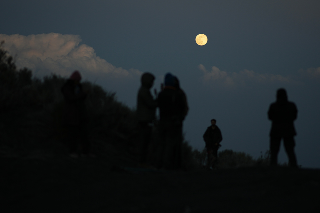 Students observe the moon near the campsite on the slopes of the Popocatepetl volcano, Mexico, Thursday, Dec. 4, 2025. (AP Photo/Eduardo Verdugo)