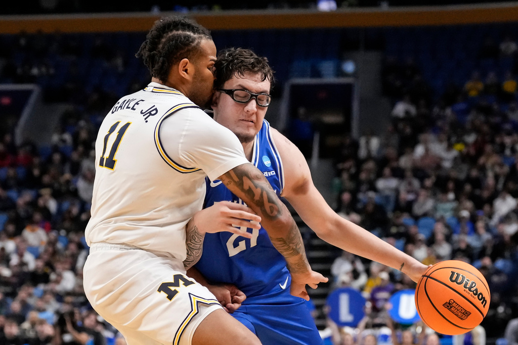Saint Louis center Robbie Avila (21) attempts to drive past Michigan guard Roddy Gayle Jr. (11) during the first half in the second round of the NCAA college basketball tournament, Saturday, March 21, 2026, in Buffalo, N.Y. (AP Photo/Yuki Iwamura)