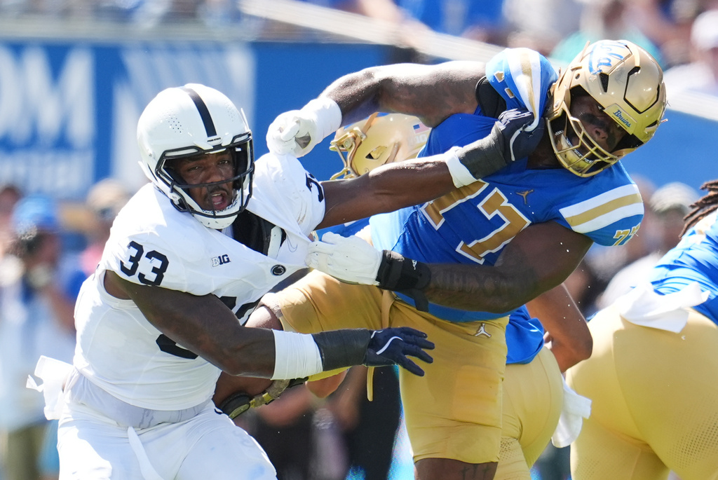 Penn State defensive end Dani Dennis-Sutton (33) runs past the block form UCLA offensive lineman Courtland Ford (77) during the first half of an NCAA college football game Saturday, Oct. 4, 2025, in Pasadena, Calif. (AP Photo/Marcio Jose Sanchez)