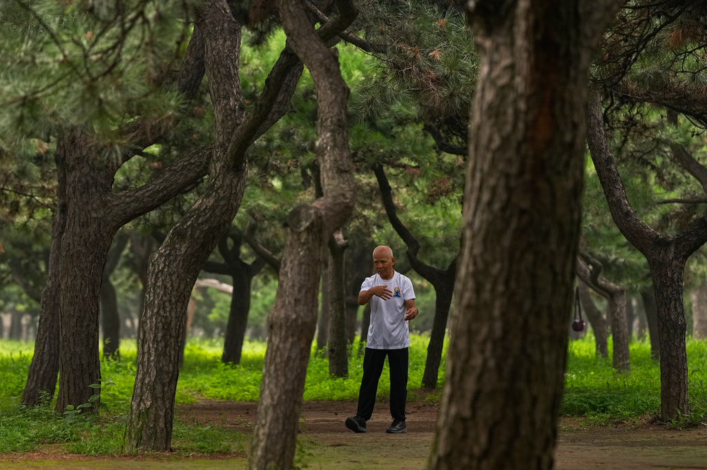 A man practices Tai Chi alone at a park near the Temple of Heaven in Beijing, Thursday July 9, 2026. (AP Photo/Andy Wong)