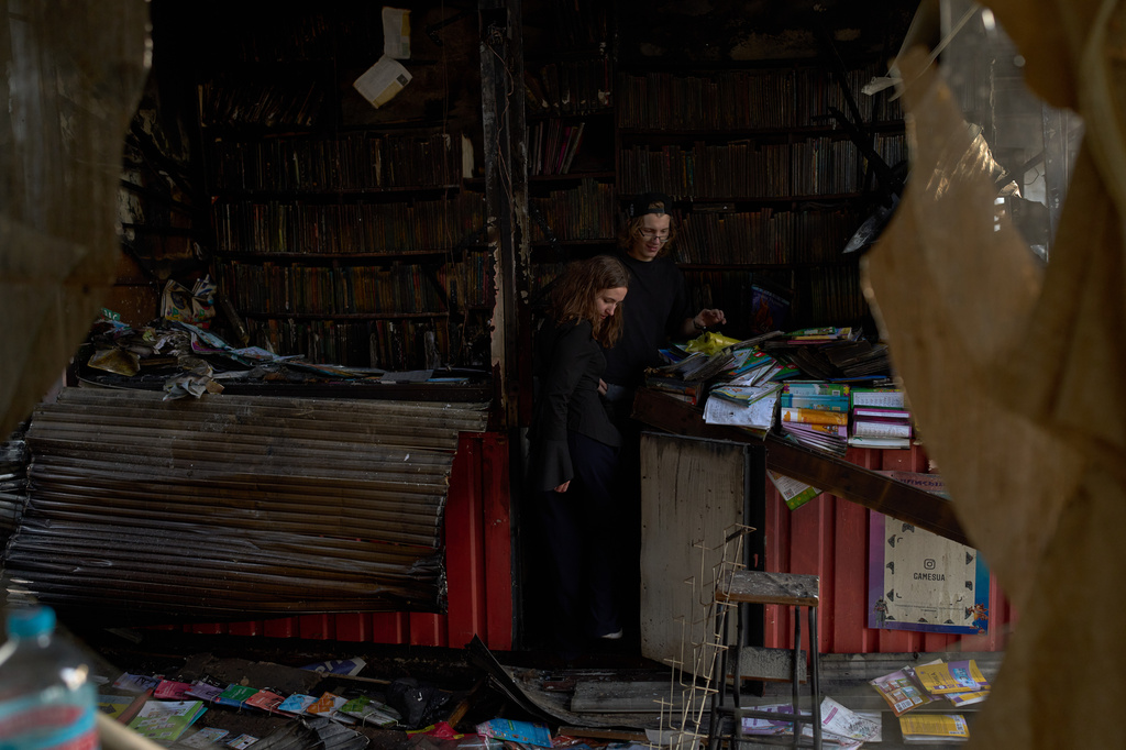 FILE - People view damage the day after a Russian missile attack at a city book market in Kyiv, Ukraine, Aug. 17, 2026. (AP Photo/Francisco Seco, File)