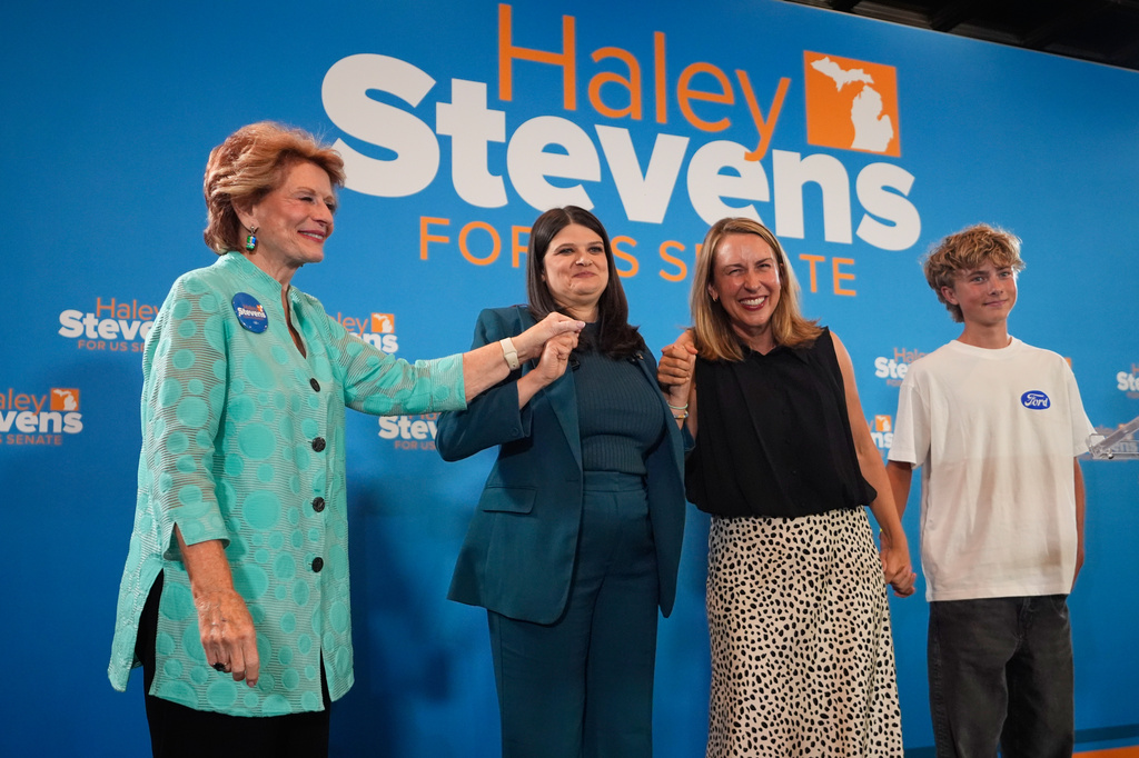 Former Sen. Debbie Stabenow, left, Rep. Haley Stevens, D-Mich., a candidate in the Democratic primary for U.S. Senate in Michigan, center left, and Rep. Hillary Scholten, D-Mich., hold hands on stage during a primary election night event Wednesday, Aug. 5, 2026, in Detroit. (AP Photo/Paul Sancya)
