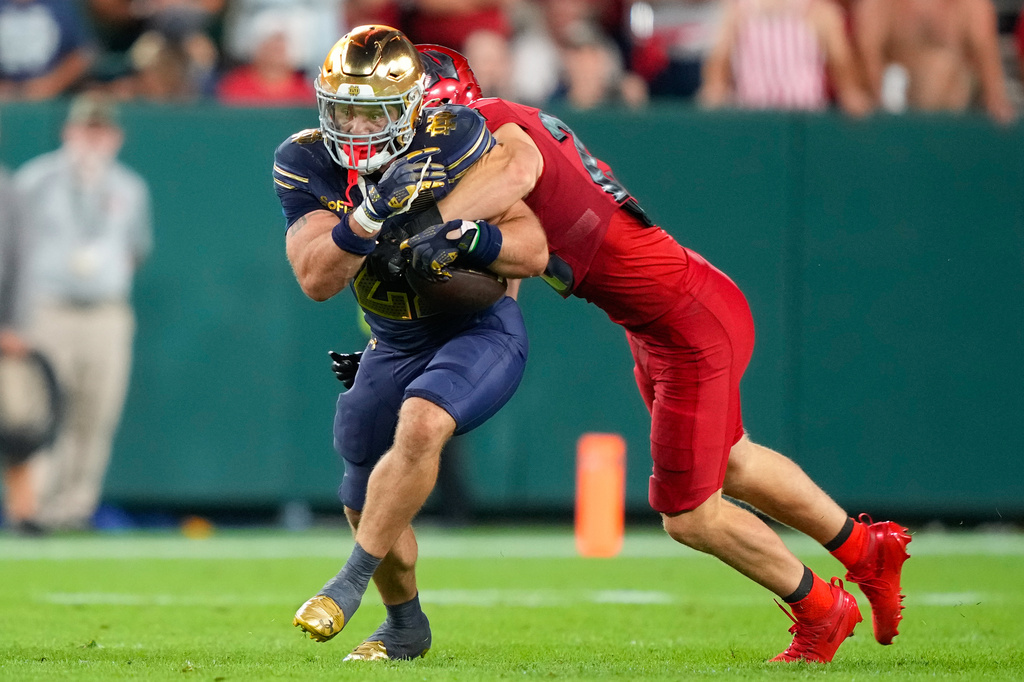 Notre Dame running back Aneyas Williams, left, is tackled by Wisconsin safety Matt Jung, right, during the second half of an NCAA college football game Sunday, Sept. 6, 2026, in Green Bay, Wis. (AP Photo/Kayla Wolf)