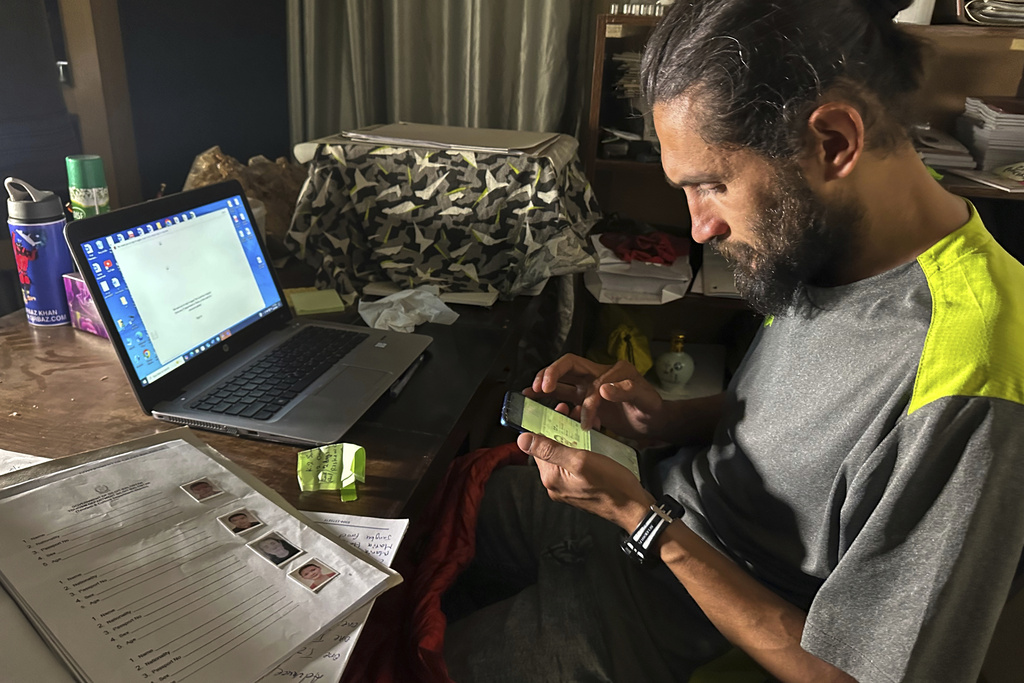 Shahbaz Khan, station manager of a Pakistani tour operator "Imagine Club Pakistan" shows passport copy and other documents of Chinese climber Guan Jing, who was killed on K2, the world's second-highest peak, at his office in Skardu, in northern Pakistan, Saturday, Aug. 16, 2025. (AP Photo/M.H. Balti)