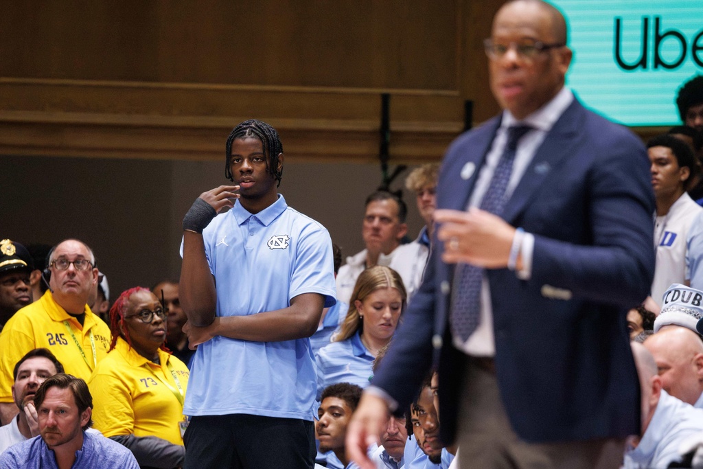 North Carolina's Caleb Wilson,left, who is injured, watches from the bench before an NCAA college basketball game against Duke in Durham, N.C., Saturday, March 7, 2026. (AP Photo/Ben McKeown)