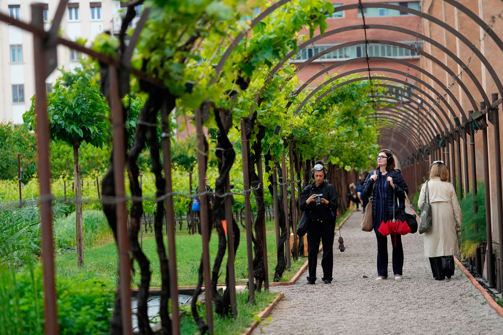 Visitors enjoy the Vatican pavilion 'The Ear Is The Eye Of The Soul' at the mystical gardens of the Carmelitani Scalzi, during the 2026 Biennale Art, in Venice, Italy, Wednesday, May 6, 2026. (AP Photo/Luca Bruno)