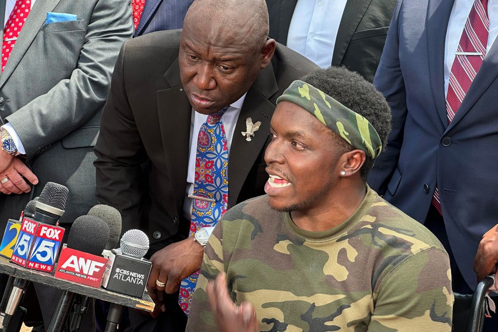 Rashaad Muhammad, right, flanked by his attorney Ben Crump, left, and other members of his legal team and supporters, speaks during a news conference outside the Fulton County Jail, in Atlanta, Wednesday, April 29, 2026. (AP Photo/Kate Brumback)