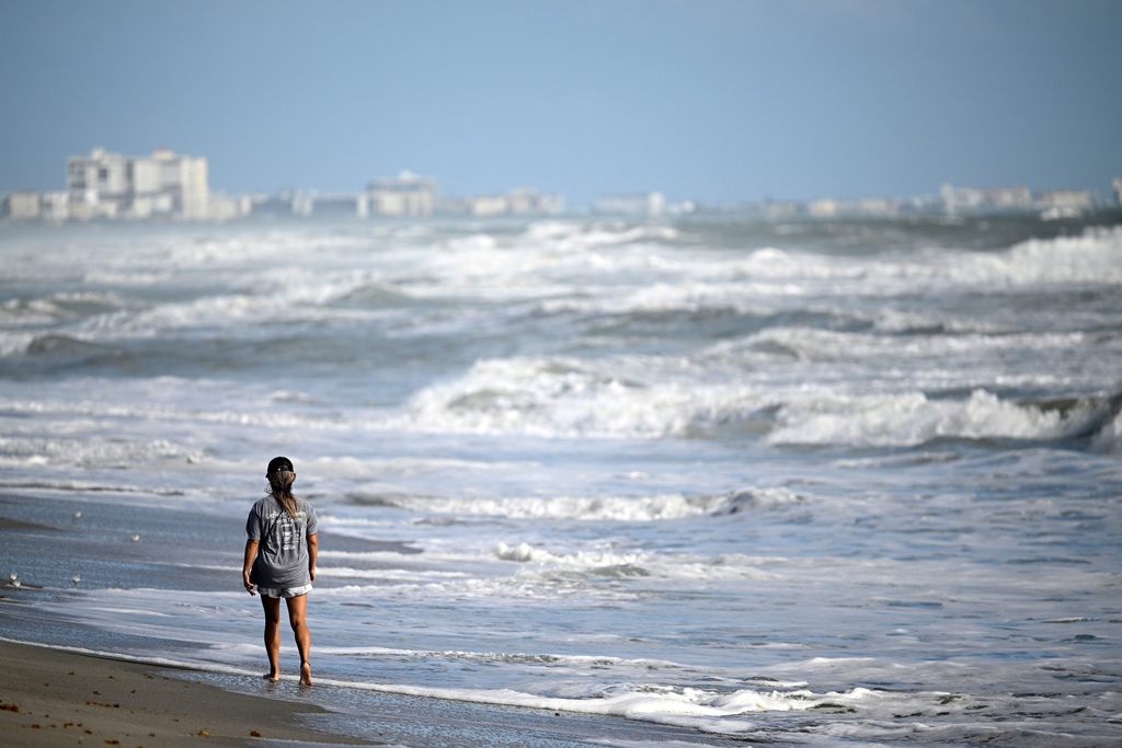 Maiko Russell walks along the sand as Tropical Storm Imelda passes offshore, kicking up the surf at Blockhouse Beach, Monday, Sept. 29, 2025, at Patrick Space Force Base, Fla. (AP Photo/Phelan M. Ebenhack)