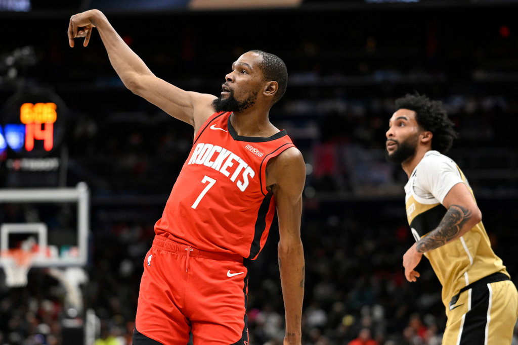Houston Rockets forward Kevin Durant (7) watches his 3-point shot go in with Washington Wizards forward Justin Champagnie during the first half of an NBA basketball game, Monday, March 2, 2026, in Washington. (AP Photo/John McDonnell)