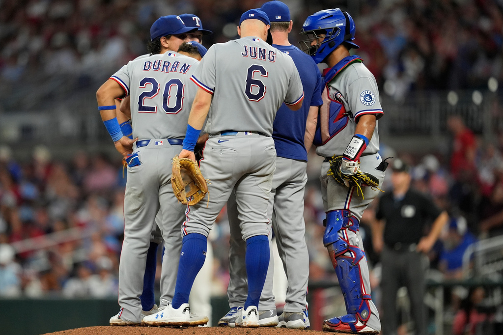 The Texas Rangers speak with pitcher Emiliano Teodo on the mound in the fifth inning of a baseball game against the Atlanta Braves, Friday, July 17, 2026, in Atlanta. (AP Photo/Mike Stewart)