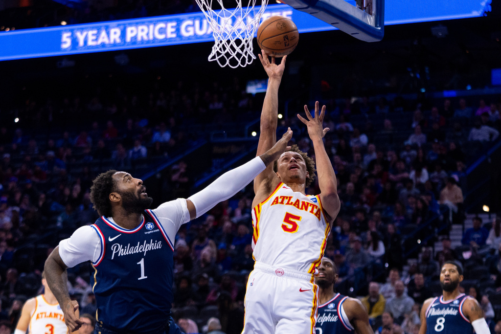 Atlanta Hawks' Dyson Daniels, right, shoots the ball with Philadelphia 76ers' Andre Drummond defending during the first half of an NBA basketball game Sunday, Nov. 30, 2025, in Philadelphia. (AP Photo/Chris Szagola)