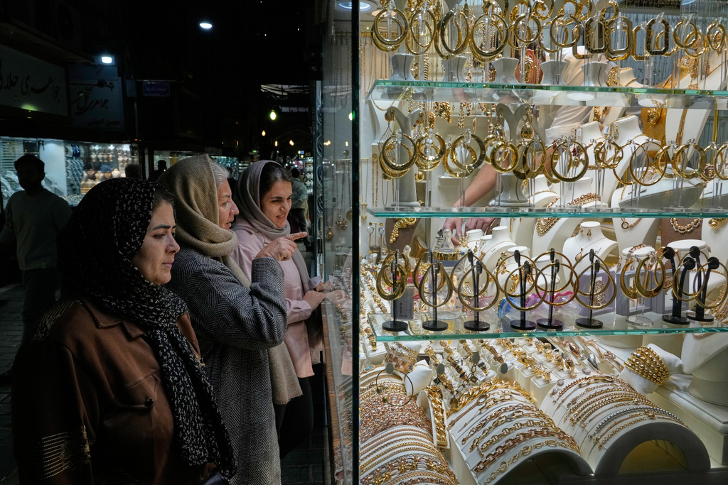 Women look at the window of a gold shop at a gold market in Tehran's Grand Bazaar, Iran, Saturday, Nov. 29, 2025. (AP Photo/Vahid Salemi)