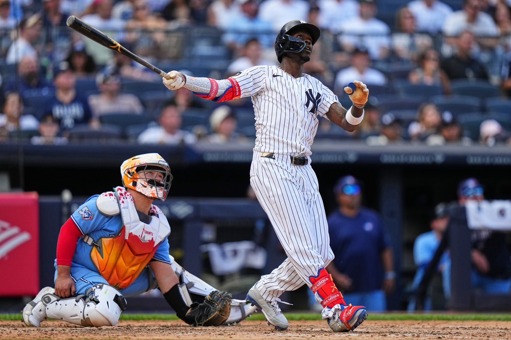 Toronto Blue Jays catcher Alejandro Kirk, left, watches as New York Yankees' Jazz Chisholm Jr. hits a two-run home run during the seventh inning of a baseball game Sunday, Aug. 23, 2026, in New York. (AP Photo/Frank Franklin II)