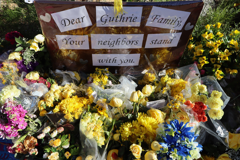 A memorial grows outside the home of Nancy Guthrie, the missing mother of "Today" show host Savannah Guthrie, Sunday, Feb. 22, 2026, in Tucson, Ariz. (AP Photo/Felicia Fonseca)
