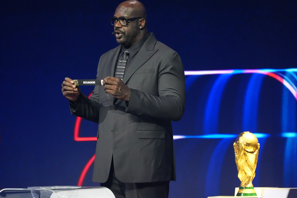 Former NBA player Shaquille O'Neal holds up the team name of Ecuador during the draw for the 2026 soccer World Cup at the Kennedy Center in Washington, Friday, Dec. 5, 2025. (AP Photo/Jacquelyn Martin)