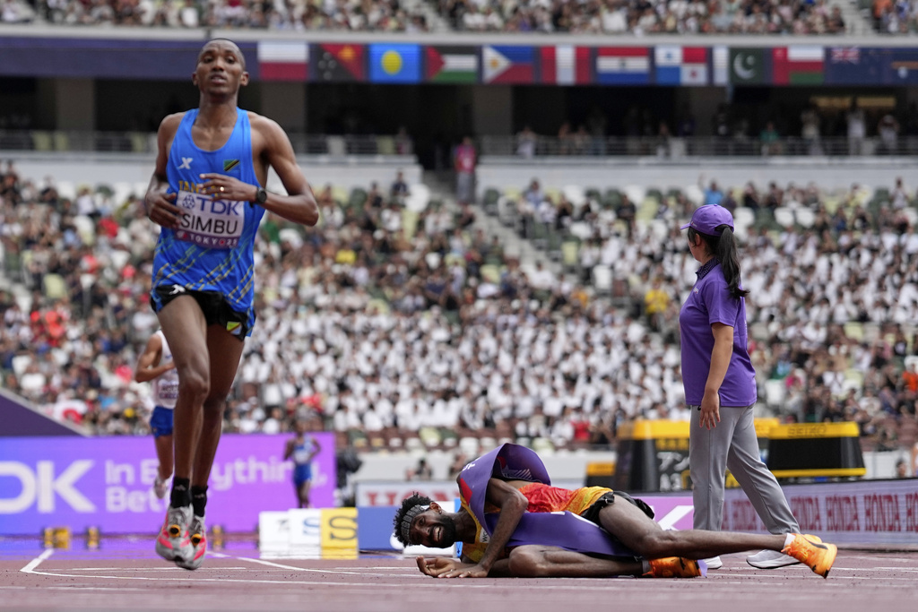 Tanzania's Alphonce Felix Simbu, left, wins the gold in the men's marathon ahead of Germany's Amanal Petros who falls at the World Athletics Championships in Tokyo, Monday, Sept. 15, 2025. (AP Photo/Petr David Josek)