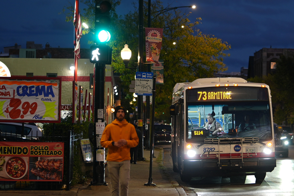 A bus drops a passenger off, across the street from Funston Elementary School in Chicago's Logan Square neighborhood, Tuesday, Oct. 14, 2025. (AP Photo/Rebecca Blackwell)