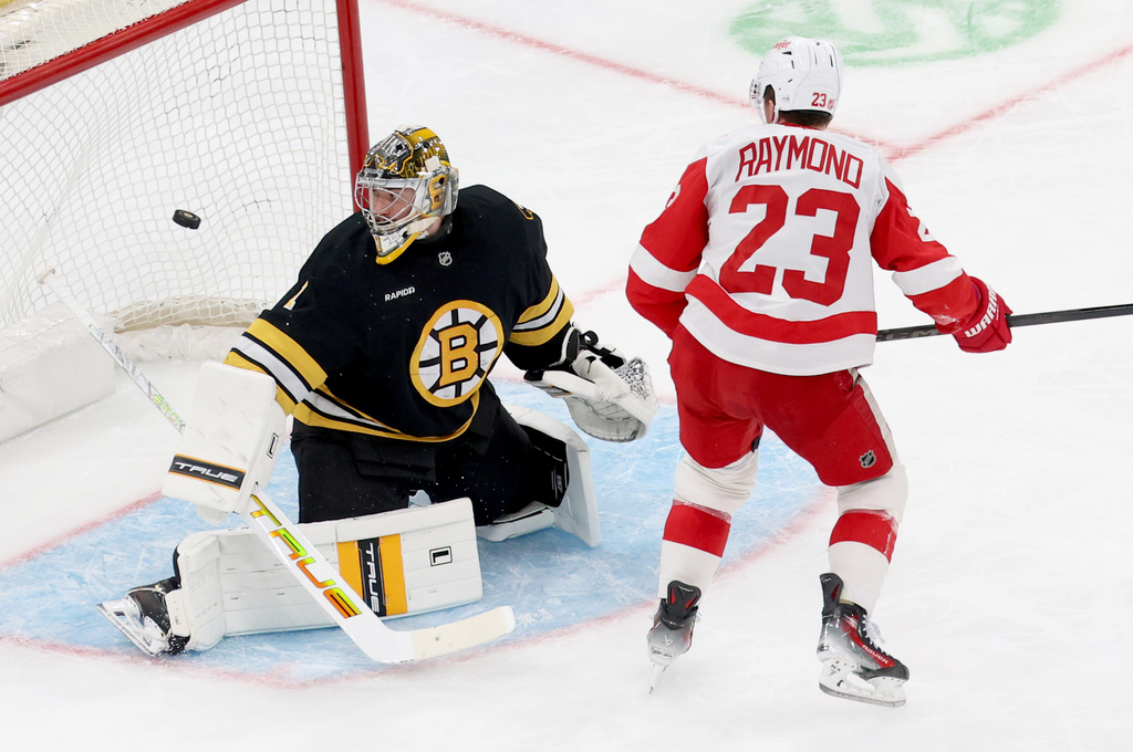 Detroit Red Wings forward Lucas Raymond (23) scores against Boston Bruins goaltender Jeremy Swayman (1) during the third period of an NHL hockey game, Saturday, Nov. 29, 2025, in Boston. (AP Photo/Mark Stockwell)