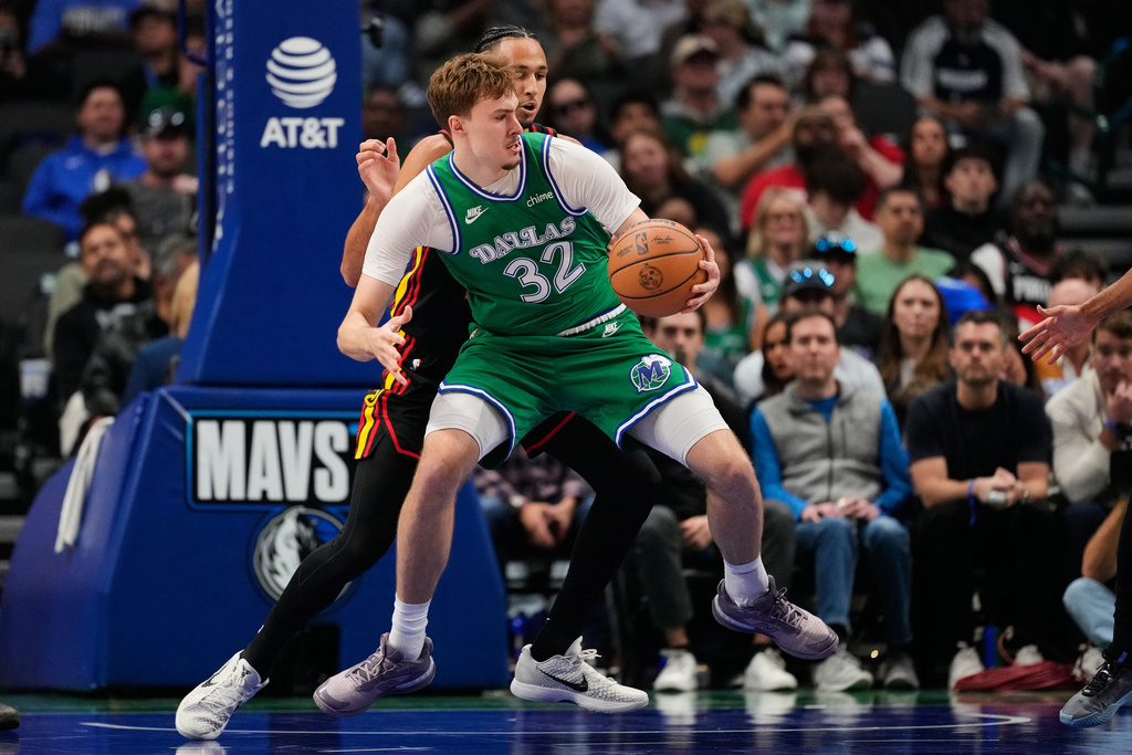 Dallas Mavericks forward Cooper Flagg (32) works for a shot against Atlanta Hawks forward Zaccharie Risacher, rear, in the first half of a NBA basketball game in Dallas, Wednesday, March 18, 2026. (AP Photo/Tony Gutierrez)