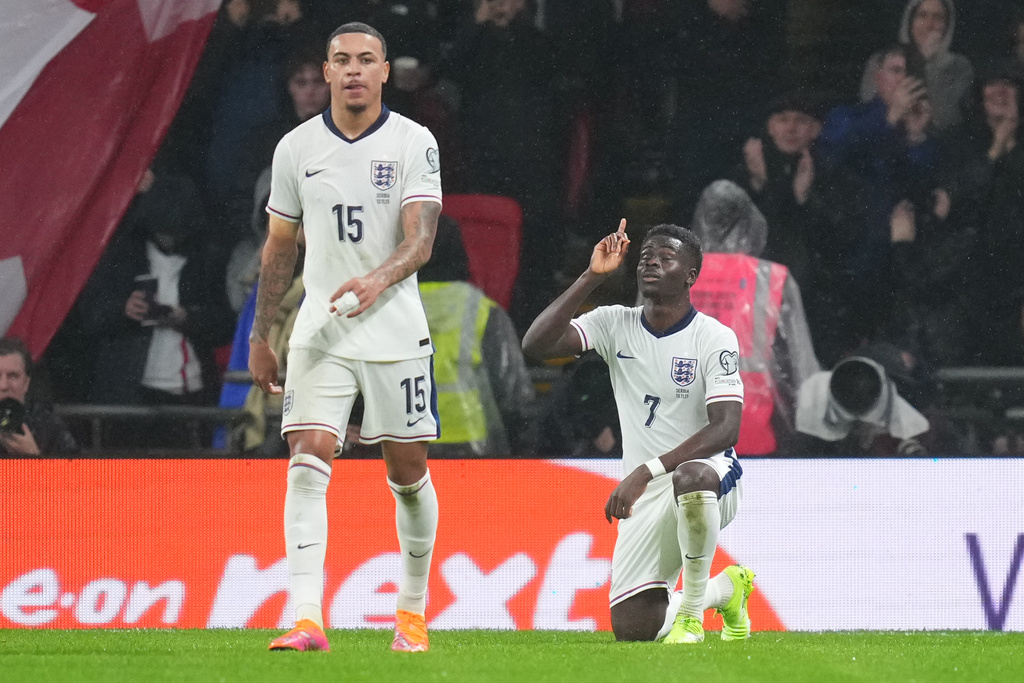 England's Bukayo Saka kneels after scoring during a World Cup qualifier group K soccer match between Serbia and England in London, Thursday, Nov. 13, 2025. (AP Photo/Kirsty Wigglesworth)