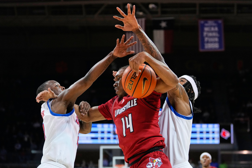 Louisville guard Adrian Wooley (14) works to the basket for a shot as SMU's Boopie Miller, left, and Jermaine O'Neal Jr., right, defend during the first half of an NCAA college basketball game in Dallas, Tuesday, Feb. 17, 2026. (AP Photo/Tony Gutierrez)