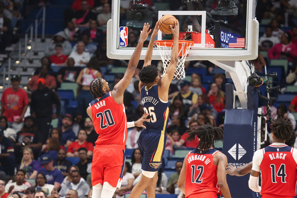 New Orleans Pelicans forward Trey Murphy III (25) gets past Washington Wizards center Alex Sarr (20) for a dunk in the second half of an NBA basketball game in New Orleans, Sunday, March 8, 2026. (AP Photo/Peter Forest)