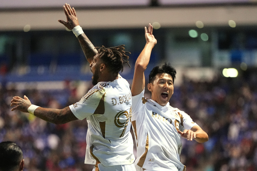 Son Heung-Min, right, congrats Denis Bouanga of the United States' Los Angeles FC after scoring his side's first goal against Mexico's Cruz Azul during a CONCACAF Champions Cup quarterfinal second leg soccer match in Puebla, Mexico, Tuesday, April 14, 2026. (AP Photo/Eduardo Verdugo)