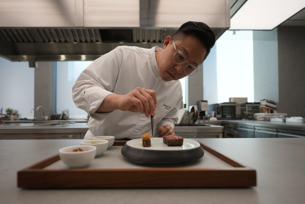 Chef Jun Lee prepares food for a photo at his restaurant SOIGNÉ in Seoul, South Korea, Thursday, Jan. 29, 2026. (AP Photo/Lee Jin-man)