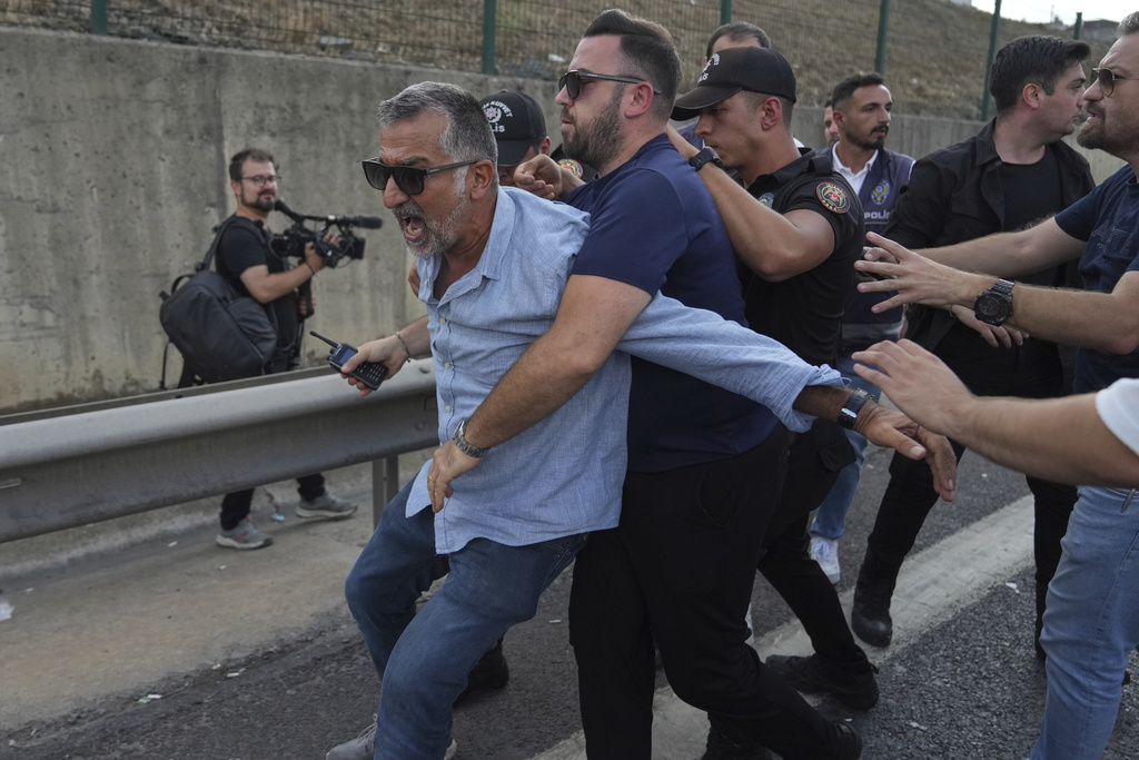 A supporter of Turkey's main opposition Republican People's Party (CHP) scuffles with police officers outside the party's headquarters in Istanbul, Turkey, Monday, Sept. 8, 2025. (AP Photo/Francisco Seco)