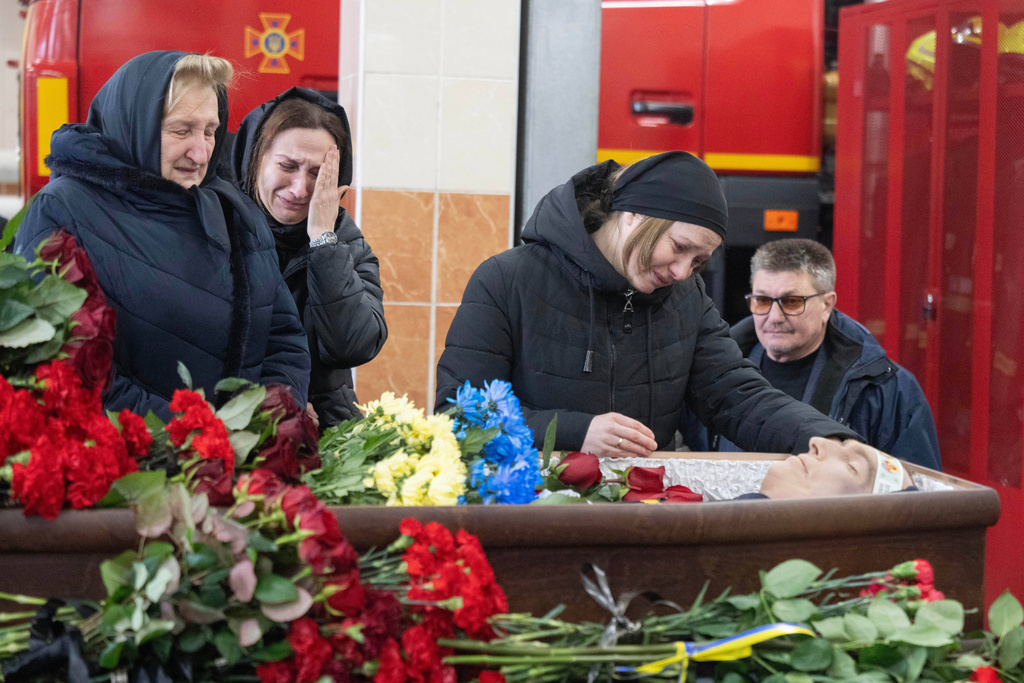 Relatives and colleagues attend the funeral of rescuer Oleksandr Zibrov, 36, who was killed in a secondary Russian drone strike on a residential building, at a fire station in Kyiv, Ukraine, Wednesday, Jan. 28, 2026. (AP Photo/Efrem Lukatsky)