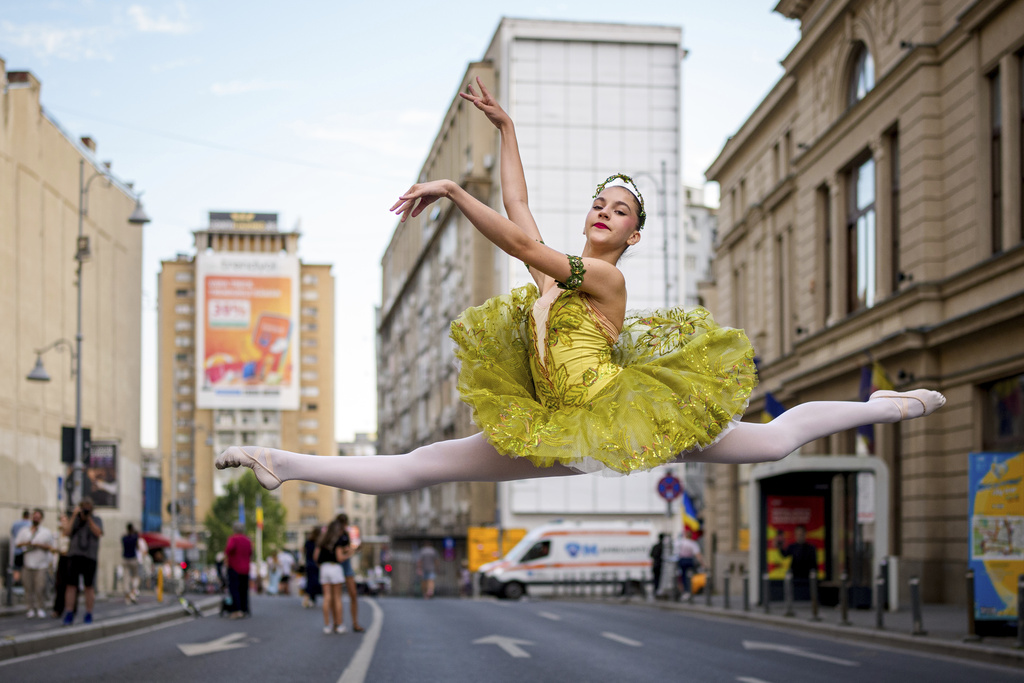 Daria Toma, 15, of the Romanian National Opera's Ballet Studio, dances outside the National History Museum of Romania during Dance Night, an event featuring a wide variety of dance styles performed on the Calea Victoriei avenue in Bucharest, Romania, Saturday, Aug. 23, 2025. (AP Photo/Andreea Alexandru)