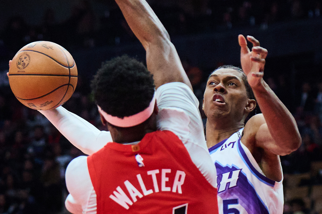 Utah Jazz's Cody Williams, right, is blocked at the net by Toronto Raptors' Ja'Kobe Walter during the first half of an NBA basketball game in Toronto, Sunday, Feb. 1, 2026. (Sammy Kogan/The Canadian Press via AP)