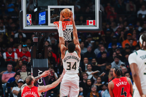 Milwaukee Bucks' Giannis Antetokounmpo (34) dunks while Toronto Raptors' Sandro Mamukelashvili (54) and Scottie Barnes (4) look on during first half NBA basketball action in Toronto on Friday, Oct. 24, 2025. (Nick Iwanyshyn/The Canadian Press via AP) Milwaukee Bucks' Giannis Antetokounmpo (34) dunks while Toronto Raptors' Sandro Mamukelashvili (54) and Scottie Barnes (4) look on during first half NBA basketball action in Toronto on Friday, Oct. 24, 2025. (Nick Iwanyshyn/The Canadian Press via AP)