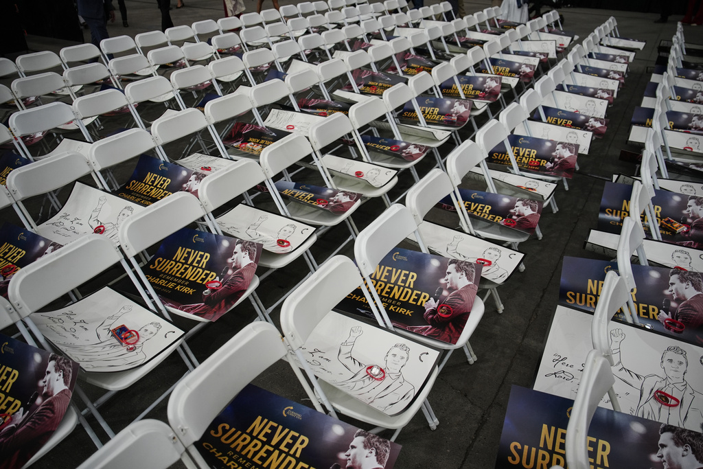 Posters of conservative activist Charlie Kirk are seen on chairs before his memorial Sunday, Sept. 21, 2025, at State Farm Stadium in Glendale, Ariz. (AP Photo/John Locher)