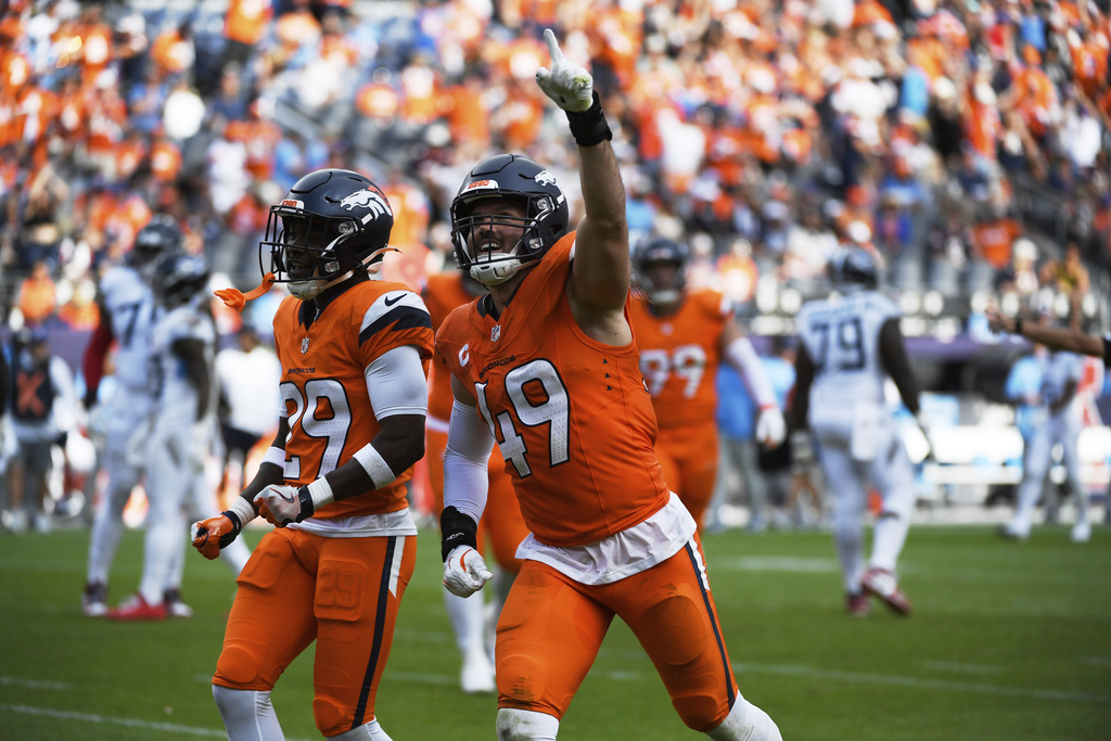 Denver Broncos cornerback Ja'Quan McMillian, left, and linebacker Alex Singleton (49) celebrate after their team recovered a fumble by Tennessee Titans quarterback Cam Ward in the second half of an NFL football game Sunday, Sept. 7, 2025, in Denver. (AP Photo/Eric Lutzens)